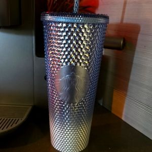 Starbucks white silver and light blue atudded cup.